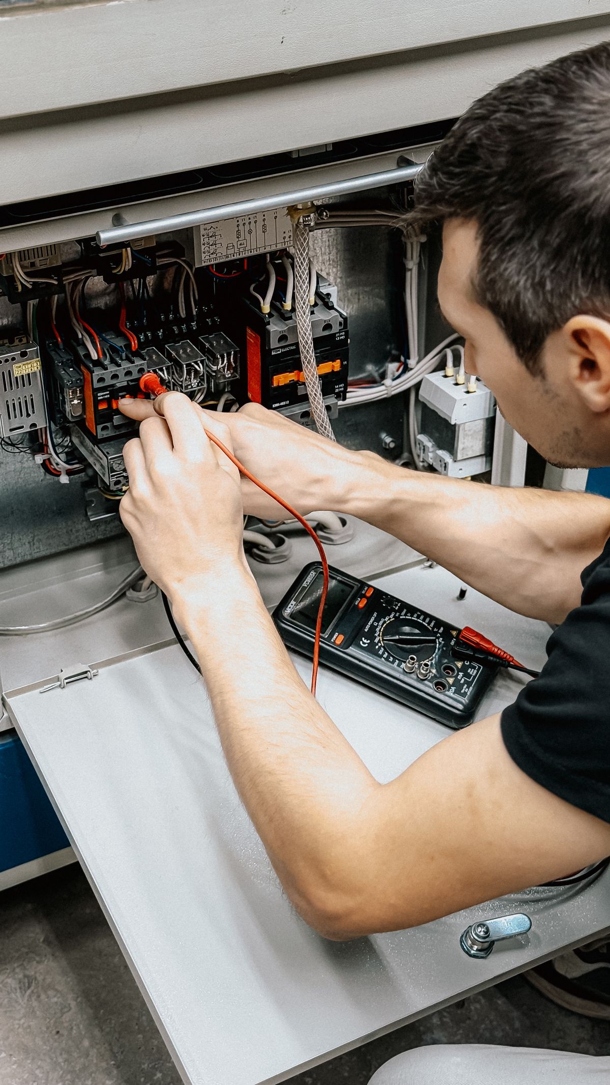 Elektryk wykonujący pomiary instalacji miernikiem
